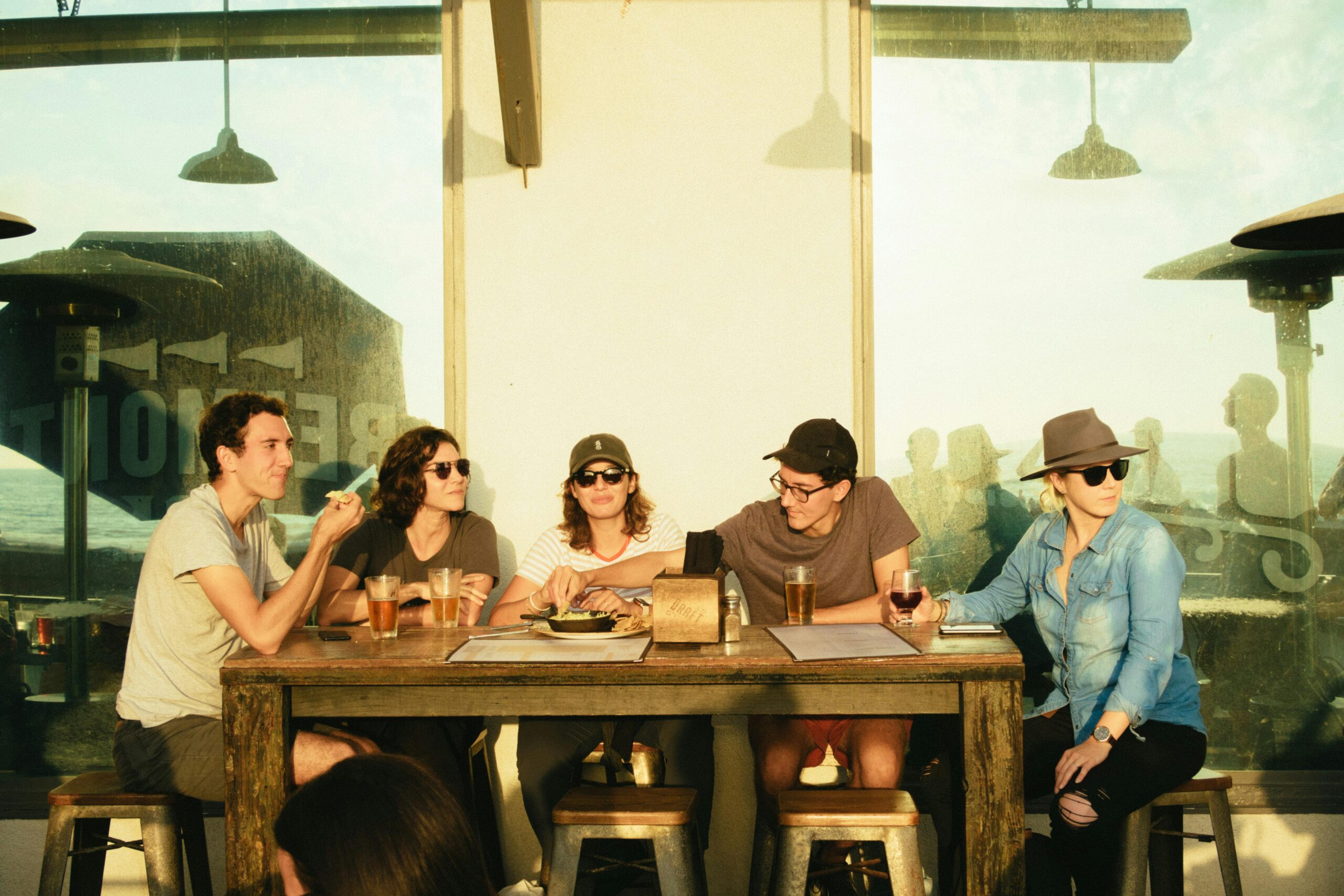5 people siting by the table talking